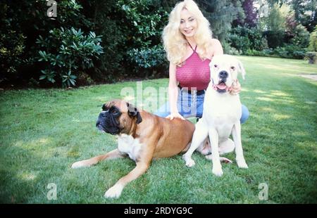 Dolly Buster, tschechische deutsche Schauspielerin Autorin und Unternehmerin, bei einer fotografischen Homestory mit ihren beiden Hunden, Deutschland 1998. Stockfoto