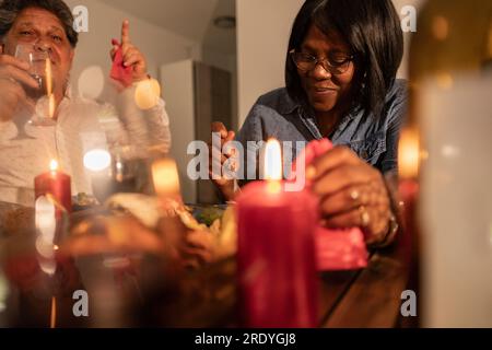 Lächelnde Seniorin, die zu Hause mit Kerzen isst Stockfoto