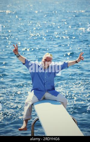 DJ Ötzi, bürgerlich Gerhard Gerry Friedle, sitzt auf einem Sprungbrett ins Meer im Urlaub im sonnigen Süden, 2000. Stockfoto