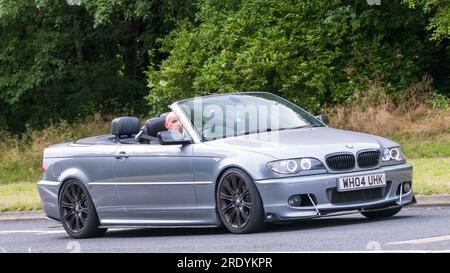 Milton Keynes, Großbritannien - Juli 21. 2023: 2004 grauer BMW 3 Serie 330 CI Sportwagen, der auf einer englischen Straße fährt Stockfoto