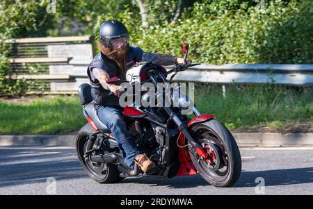 Milton Keynes, Großbritannien - Juli 23. 2023: Mann fährt ein Harley Davidson Motorrad auf einer englischen Straße Stockfoto