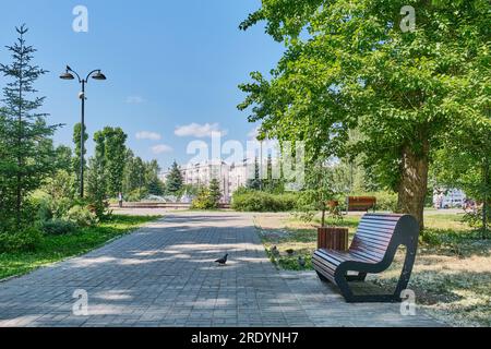 Kasan, Russland - 9. Juni 2023: Bank auf der Gasse im öffentlichen Stadtpark, benannt nach Karim Tinchurin. Sommerliche Stadtlandschaft. Stockfoto