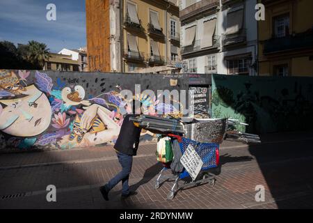 Obdachloser mit seinem Hab und gut vor Street Art in der Altstadt von Valencia *** Obdachloser mit seinen Habseligkeiten vor der Straßenkunst in der alten Stockfoto