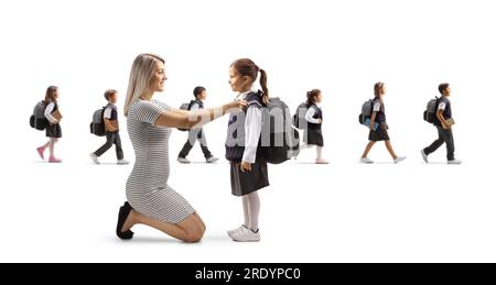 Mutter, die der Tochter hilft, sich für die Schule vorzubereiten, und andere Kinder, die isoliert auf weißem Hintergrund durch den Rücken laufen Stockfoto