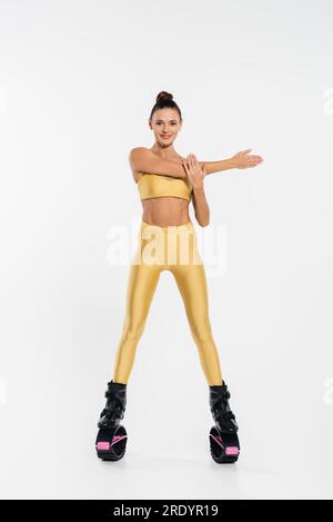 Fröhliche Frau in Fitnesskleidung und kangoo-Sprungschuhen, weißer Hintergrund, Energie Stockfoto