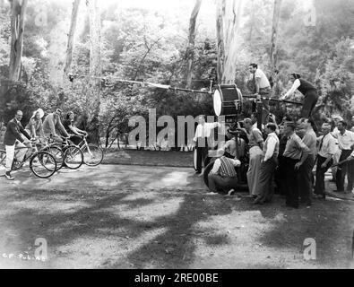 FRED ASTAIRE GINGER ROGERS RALPH BELLAMY und LUELLA AUSRÜSTUNG auf Fahrrädern am Set, offen mit Movie Crew, einschließlich Director MARK SANDRICH (über dem Studiolicht) und Cinematographen ROBERT DE GRASSE (unter Sandrich in hellen Hosen) Während der Dreharbeiten von CAREFREE 1938 Regisseur MARK SANDRICH Musik und Texte Irving Berliner Produzent Pandro S. Berman RKO Radio Pictures Stockfoto