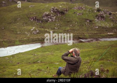 Ein erwachsener Rentner blickt auf den Lachs River in Schottland Stockfoto