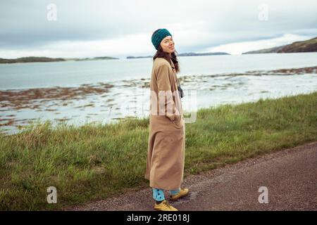 Ein asiatisches Mädchen lächelt vor der Kamera auf der Straße am Bergsee Stockfoto