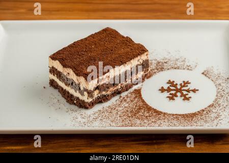 Tiramisu serviert mit Schokolade auf einem weißen Porzellanteller Stockfoto