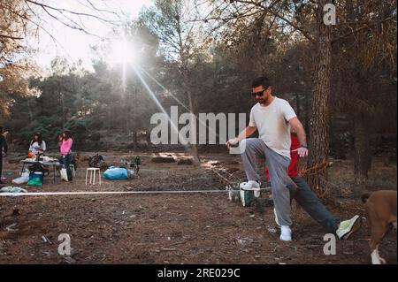 Ein Mann, der mit Freunden im Kiefernwald in südspanien sackelt Stockfoto