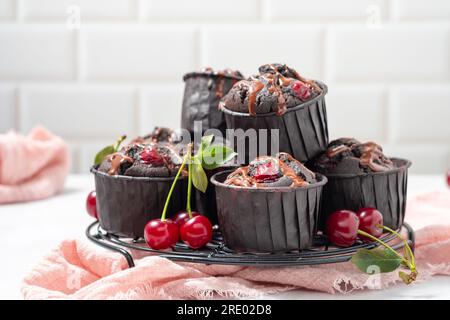 Schokoladen-Muffins mit frischen Sauerkirschen Stockfoto