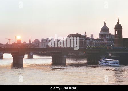 Sonnenuntergang über der Cannon Street Railway Bridge und St Paul's Cathedral, London, England. Ca. 1980er Jahre Stockfoto