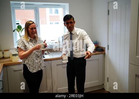 Premierministerin Rishi Sunak spricht mit der Hausbesitzerin Jennifer Norton, die bei einem Besuch im Cofton Park in der Nähe von Rednal, Birmingham, eine Tasse Tee in einer Tasse Nummer 10 in ihrem Haus trinkt. Foto: Montag, 24. Juli 2023. Stockfoto