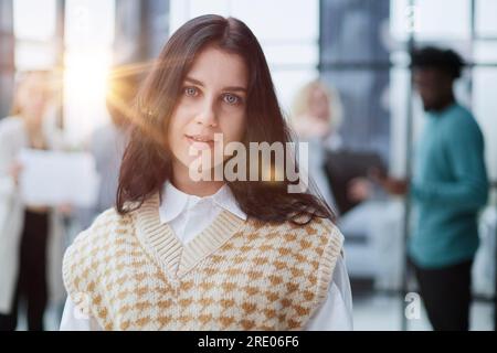 Porträt einer fröhlichen jungen Frau, die im Amt steht Stockfoto