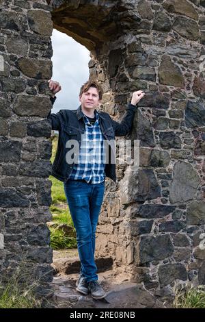 St Anthony's Chapel Holyrood Park, Edinburgh, Schottland, Großbritannien, 24. Juli 2023. Mike Baillie Musikvideo für Fringe Show: Frontman von Band The Lonely Together filmt ein neues Musikvideo für seine Debüt-Fringe-Show Endless Sunset Oblivion, die die Geschichte eines jungen Songwriters Reuben erzählt, der versucht, die beschleunigten Probleme der Welt zu bekämpfen. Der Song im Video wurde an diesem Ort geschrieben. Kredit: Sally Anderson/Alamy Live News Stockfoto