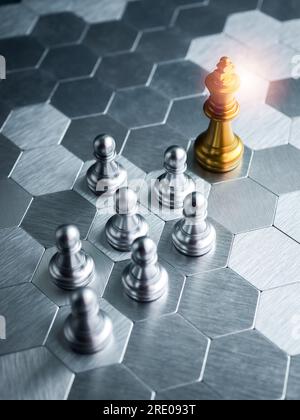 Das goldene Schachspiel des Königs steht vor silbernen Schachfiguren auf einem silbernen, sechseckigen Brett-Hintergrund. Führung, Follower, Team, Kommunikation Stockfoto