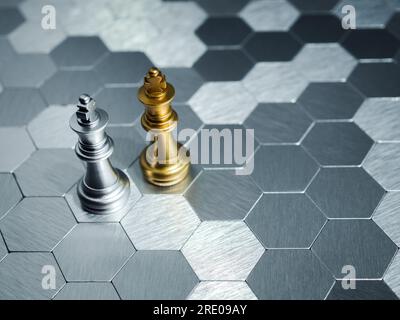 Ein goldenes King-Schachstück und ein silbernes King-Schachstück stehen auf einem sechseckigen Brett-Hintergrund zusammen. Führung, Partnerschaft, Mitbewerber Stockfoto