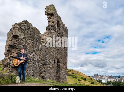 St Anthony's Chapel Holyrood Park, Edinburgh, Schottland, Großbritannien, 24. Juli 2023. Mike Baillie Musikvideo für Fringe Show: Frontman von Band The Lonely Together filmt ein neues Musikvideo für seine Debüt-Fringe-Show Endless Sunset Oblivion, die die Geschichte eines jungen Songwriters Reuben erzählt, der versucht, die beschleunigten Probleme der Welt zu bekämpfen. Der Song im Video wurde an diesem Ort geschrieben. Kredit: Sally Anderson/Alamy Live News Stockfoto