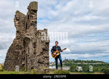 St Anthony's Chapel Holyrood Park, Edinburgh, Schottland, Großbritannien, 24. Juli 2023. Mike Baillie Musikvideo für Fringe Show: Frontman von Band The Lonely Together filmt ein neues Musikvideo für seine Debüt-Fringe-Show Endless Sunset Oblivion, die die Geschichte eines jungen Songwriters Reuben erzählt, der versucht, die beschleunigten Probleme der Welt zu bekämpfen. Der Song im Video wurde an diesem Ort geschrieben. Kredit: Sally Anderson/Alamy Live News Stockfoto