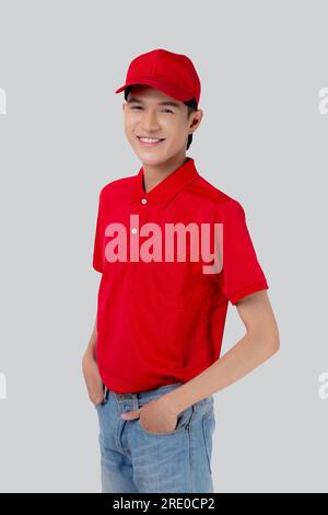 Porträtieren Sie einen jungen asiatischen Mann in Uniform, stehen Sie und lächeln Sie mit einem selbstbewussten, isolierten weißen Hintergrund, Mitarbeiter oder Händler, Kurier und Zusteller, Zusteller Stockfoto