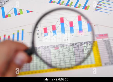 Geschäftsmann, der eine Lupe in Betracht zieht Stockfoto