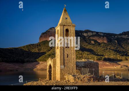 Glockenturm von Sant Romà de Sau bei Sonnenaufgang mit fast leerem Sau-Reservoir während der Dürre 2022-23 (Osona, Barcelona, Katalonien, Spanien) Stockfoto