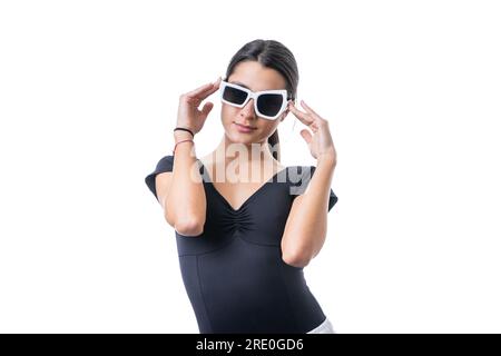 Studioporträt einer jungen braunen Model-Frau, die eine lustige, schicke weiße Sonnenbrille trägt Stockfoto