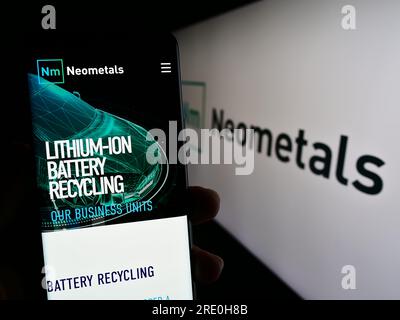 Person, die ein Mobiltelefon mit der Website des australischen Batterieherstellers Neometals Ltd. Auf dem Bildschirm vor dem Logo hält. Konzentrieren Sie sich auf die Mitte des Telefondisplays. Stockfoto