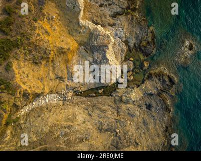 Zenithaler Blick aus der Vogelperspektive auf die steilen Felsen an der Küste nahe Cap de s'Arnella, Cap de Creus, nördlich der Costa Brava (Alt Empordà, Girona, Katalonien, Spanien) Stockfoto