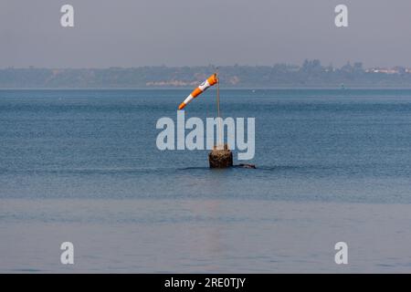 Eine Windsocke oder ein Windkegel, der in Windrichtung in der Mitte des Meeres zeigt Stockfoto