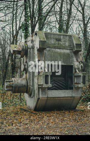 Alte und verrostete Erzschleifmaschine im Herbst im Wald. Verlassene Maschinen aus industrieller Geschichte. Eisen- und Stahlproduktion. Stockfoto