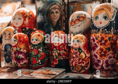 Handbemalte berühmte russische Holzpuppe Matryoschka. Weibliche Zeichentrickgesichter mit rotem Lippenstift und rosigen Wangen. Traditionelles Souvenir Stockfoto