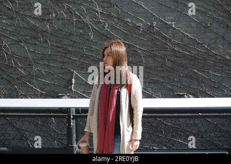 Asiatische Frau steht allein in der Nähe der Mauer in New York City Stockfoto