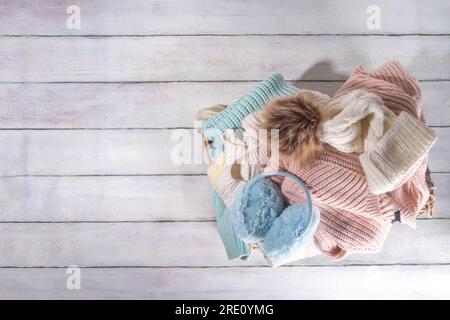 Vorbereitung für Herbst- und Wintersaison, warme kuschelige Herbstkleidung, ein Stapel sauberer, frisch gewaschener, ordentlich gefalteter Jacken, Pullover, Decken, Hüte, M Stockfoto