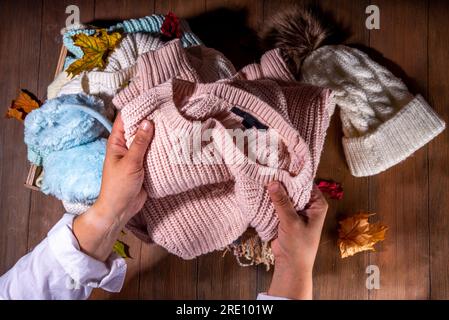 Vorbereitung für Herbst- und Wintersaison, warme kuschelige Herbstkleidung, ein Stapel sauberer, frisch gewaschener, ordentlich gefalteter Jacken, Pullover, Decken, Hüte, M Stockfoto