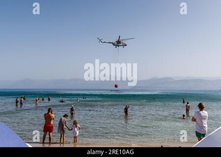 Korfu, Griechenland. 24. Juli 2023. Wilde Brände auf Korfu, Griechenland Ein Hubschrauber saugt Wasser aus dem Agios Spiridon Beach auf Korfu, bevor er es auf die nahe gelegenen Waldbrände absetzt 24.07.23 Gutschrift: Roy Riley/Alamy Live News Stockfoto