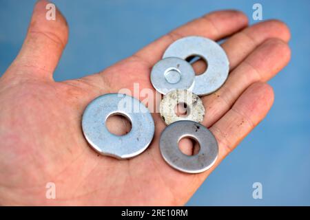 Silberne Eisenscheiben in der Hand eines Mannes Stockfoto