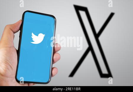 San Francisco, USA, Juli 23 2023: Hand hält ein Mobiltelefon mit der Twitter X-Anwendung auf dem Bildschirm. Das neue X-Logo ist im Hintergrund verschwommen. ICH Stockfoto