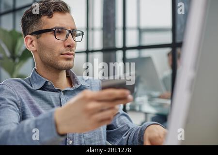 geschäftsmann mit seitlichem Blickwinkel, der in einem modernen Büro am Computer-pc-Laptop tippt Stockfoto