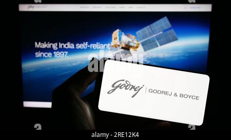 Person, die ein Smartphone mit dem Logo des indischen Unternehmens Godrej und Boyce Mfg. Co. Ltd. Auf dem Bildschirm vor der Website hält. Konzentrieren Sie sich auf das Display des Telefons. Stockfoto