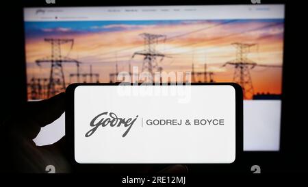 Person, die ein Mobiltelefon mit dem Logo der indischen Firma Godrej und Boyce Mfg. Co. Ltd. Auf dem Bildschirm vor der Webseite hält. Konzentrieren Sie sich auf das Display des Telefons. Stockfoto