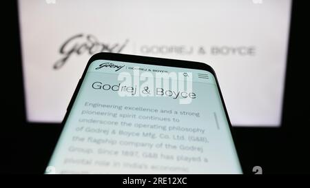 Mobiltelefon mit Webseite der indischen Firma Godrej und Boyce Mfg. Co. Ltd. Auf dem Bildschirm vor dem Logo. Fokus auf oberer linker Seite des Telefondisplays. Stockfoto