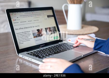 Frau, die Angebote für Strom und Gas auf der Website eines Energieversorgers liest. Auf dem Bildschirm wird die EDF-Website (French Electricity Board) Stockfoto