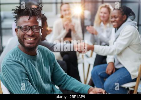 Afrikanischer Geschäftsmann mit einer Gruppe von Geschäftsleuten im Hintergrund Stockfoto