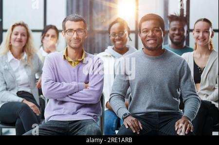 Junge Geschäftsleute hören sich einen Vortrag im Konferenzsaal an. Stockfoto