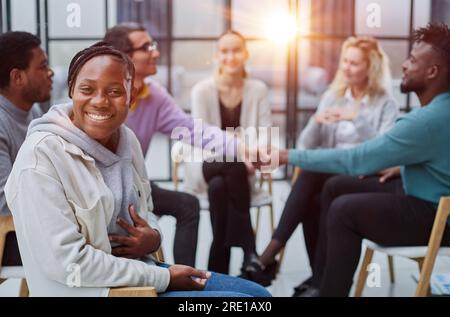 Erfolgreiche afroamerikanische Managerin, die vor ihren Kollegen sitzt Stockfoto