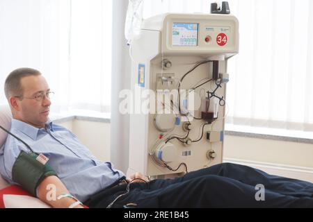 Erfurt, Deutschland. 24. Juli 2023. Spender Patrick Kanzler liegt während einer Plasmaspende im Blutspendezentrum Hama auf einer Couch. Darüber hinaus werden Informationen über die Bedeutung von Blut- und Plasmaspenden bereitgestellt. Kredit: Bodo Schackow/dpa/Alamy Live News Stockfoto