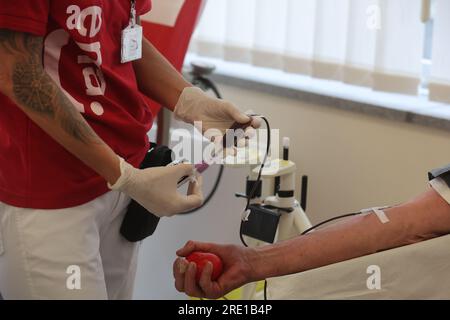 Erfurt, Deutschland. 24. Juli 2023. Eine Krankenschwester hält die Ausrüstung für Blutspenden in einem Raum des Blutspendezentrums von Hama. Während einer Spende werden auch Informationen über die Bedeutung von Blut- und Plasmaspenden bereitgestellt. Kredit: Bodo Schackow/dpa/Alamy Live News Stockfoto