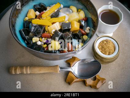 Schwarzgrassgelee umfasst Nüsse, Müsli, rote Bohnen, Ginkgo, geschnittene ​​pumpkin, Maiskerne, Millet, gewürfelte Süßkartoffeln, Palmenkerne und Gelee Stockfoto