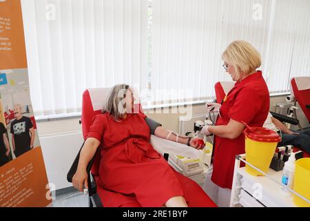 Erfurt, Deutschland. 24. Juli 2023. Heike Werner (die Linke, l), Gesundheitsministerin von Thüringen, liegt während einer Blutspendekampagne im Blutspendezentrum Hama auf einer Couch und wird von Krankenschwester Ines betreut. Er wird auch über die Bedeutung von Blut- und Plasmaspenden informiert. Kredit: Bodo Schackow/dpa/Alamy Live News Stockfoto